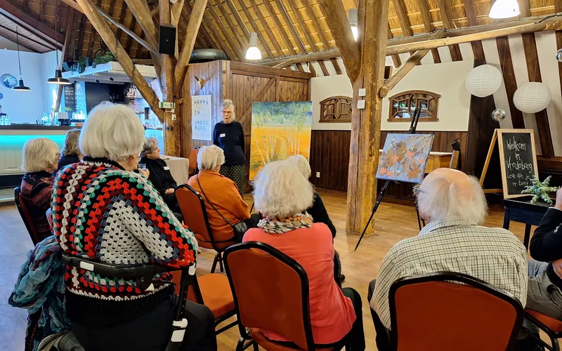 Bezoekers luisteren naar een lezing in een zaal
